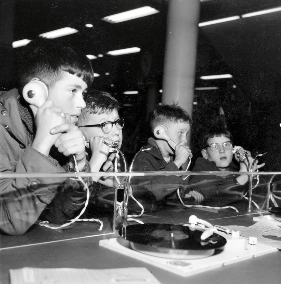 Pojkar provlyssnar med hörlurar i en nederländsk skivaffär, november 1957. Foto: G.A. van der Chijs/Nationaal Archief, inga kända upphovsrättsliga begränsningar. Pojkar provlyssnar med hörlurar i en nederländsk skivaffär, november 1957.